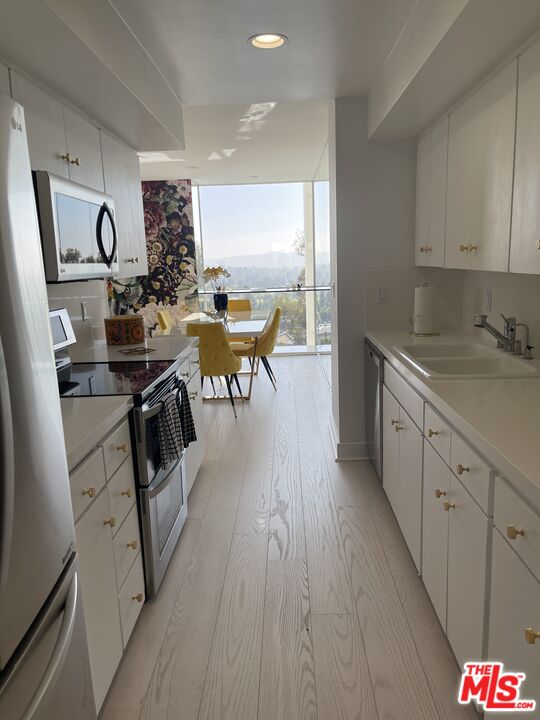 2222 Avenue Of The Stars, Unit 705 Los Angeles, CA 90067 - Photo 10 of 36 a view of a kitchen with kitchen island granite countertop a large counter top space a sink appliances and cabinets