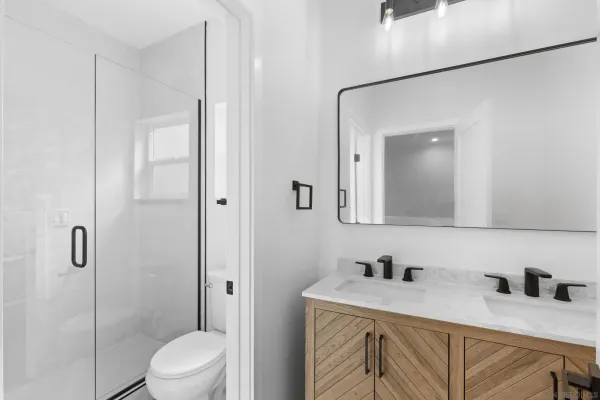 a bathroom with a granite countertop sink vanity mirror and toilet