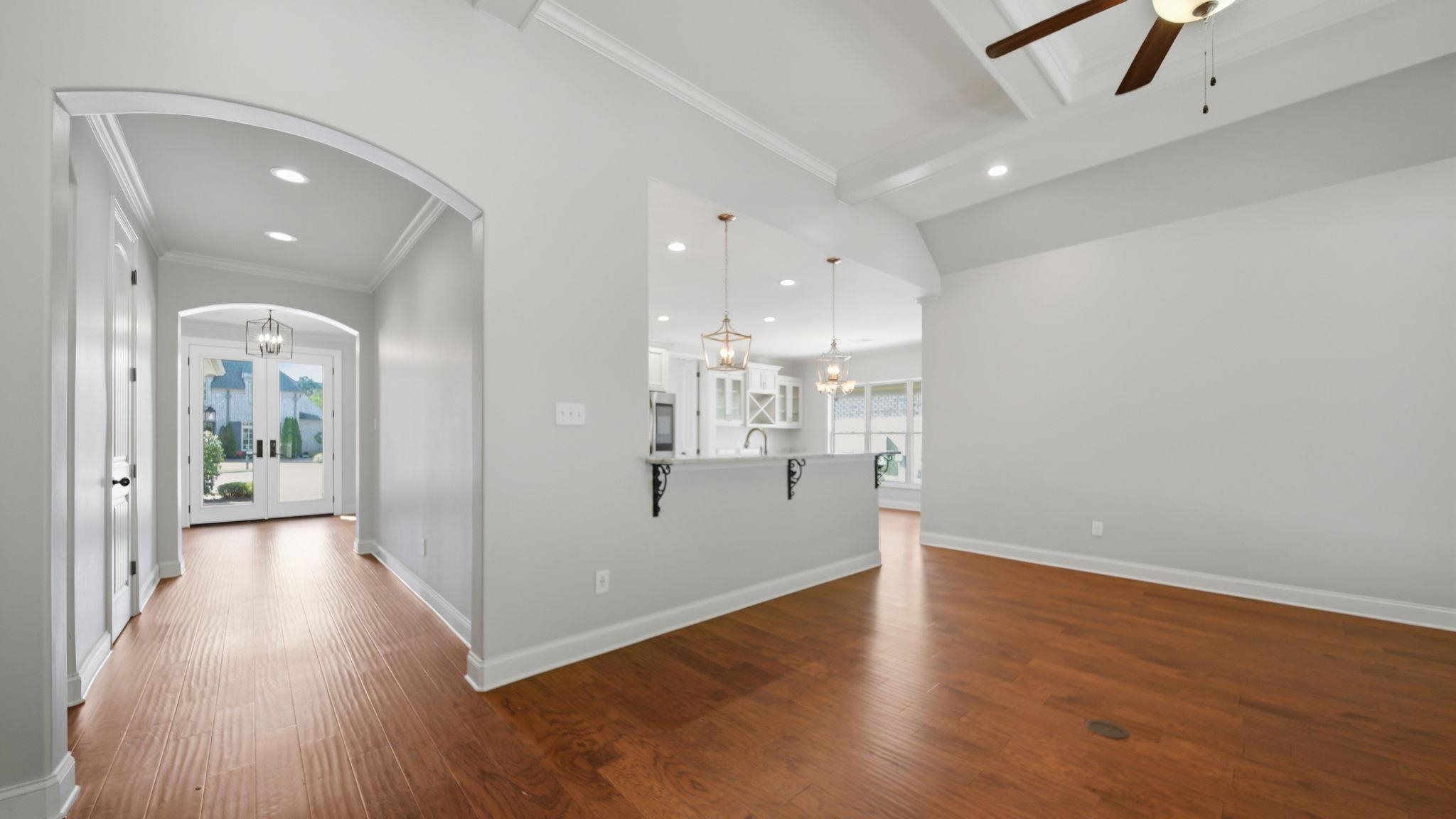 1058 Shanborne Cove Collierville, TN 38017 - Photo 14 of 39 Corridor featuring dark wood finished floors, a chandelier, arched walkways, and crown molding