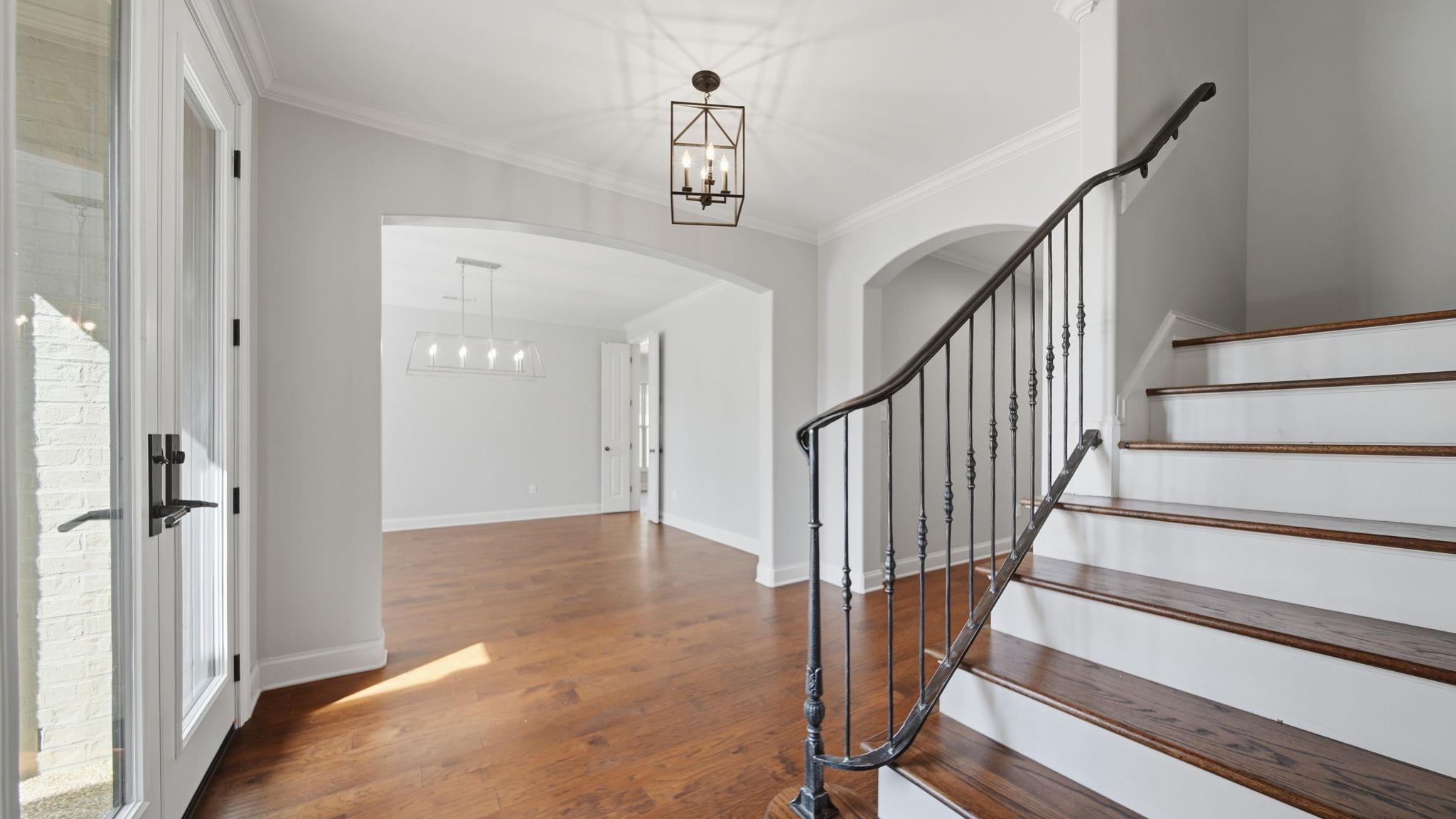 1058 Shanborne Cove Collierville, TN 38017 - Photo 17 of 39 Foyer entrance with a chandelier, dark wood-style flooring, crown molding, and arched walkways