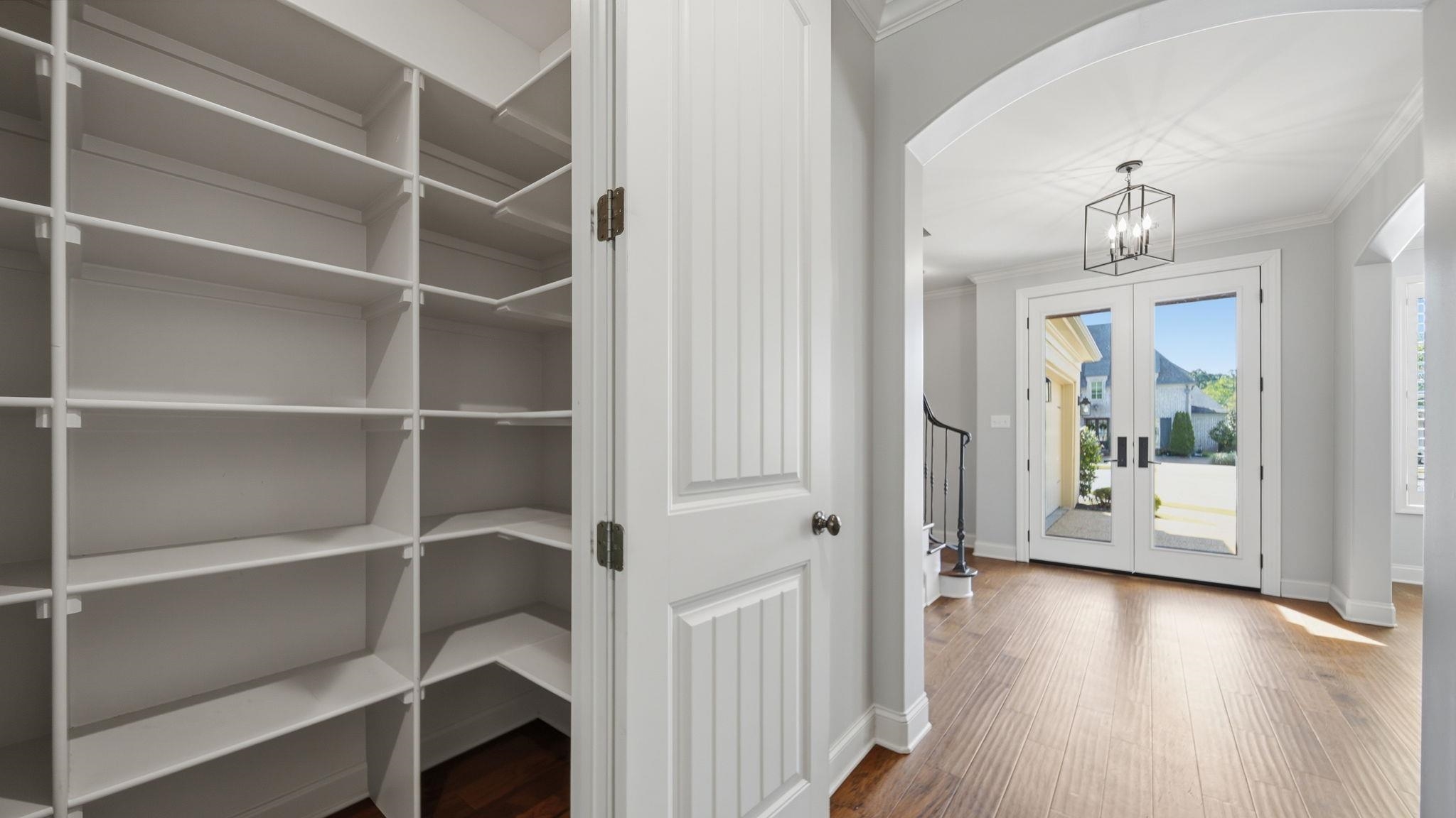 1058 Shanborne Cove Collierville, TN 38017 - Photo 18 of 39 Foyer entrance featuring arched walkways, french doors, dark wood-type flooring, crown molding, and a chandelier