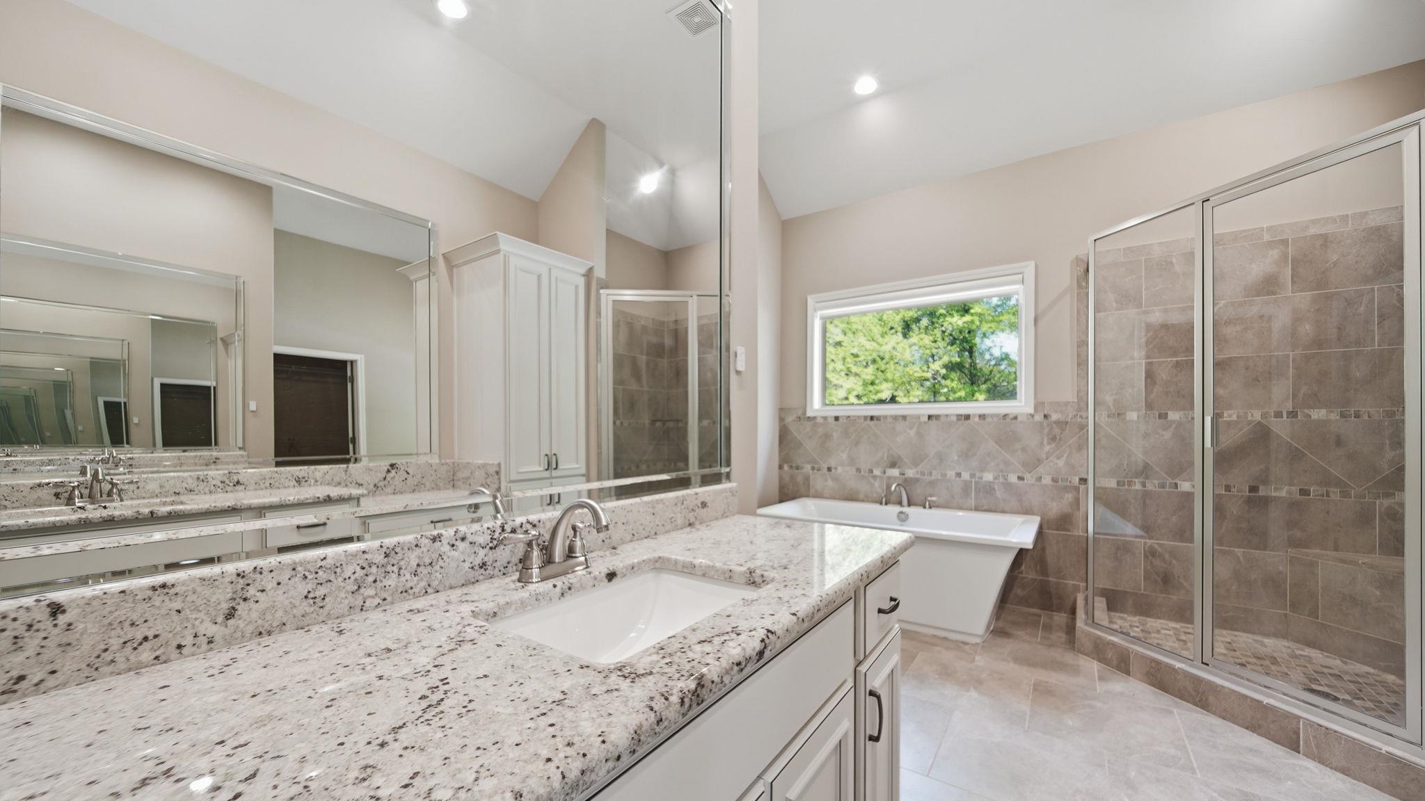 1058 Shanborne Cove Collierville, TN 38017 - Photo 22 of 39 Full bathroom with a shower stall, vanity, lofted ceiling, a soaking tub, and tile walls