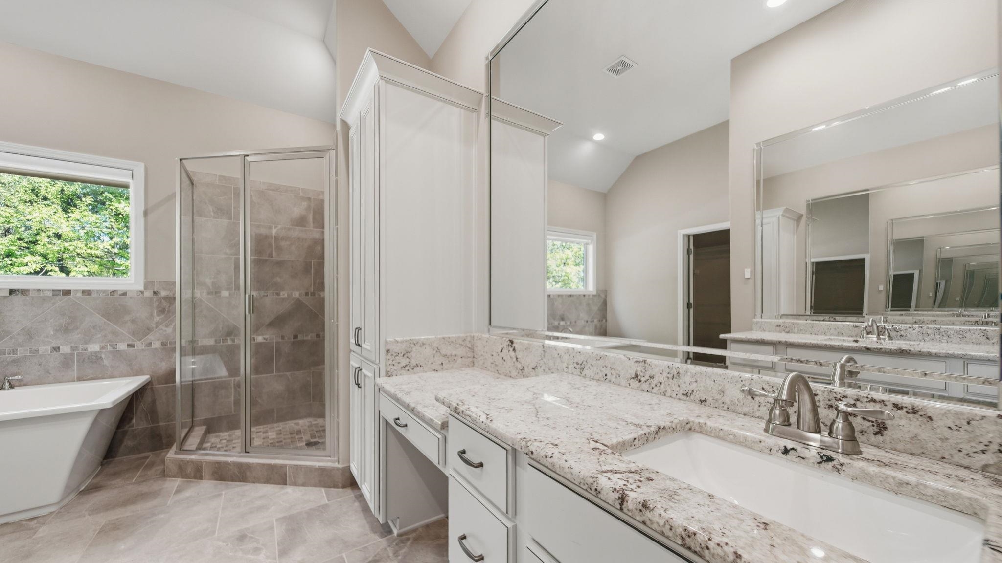 1058 Shanborne Cove Collierville, TN 38017 - Photo 23 of 39 Full bathroom with a shower stall, vanity, a freestanding tub, and vaulted ceiling