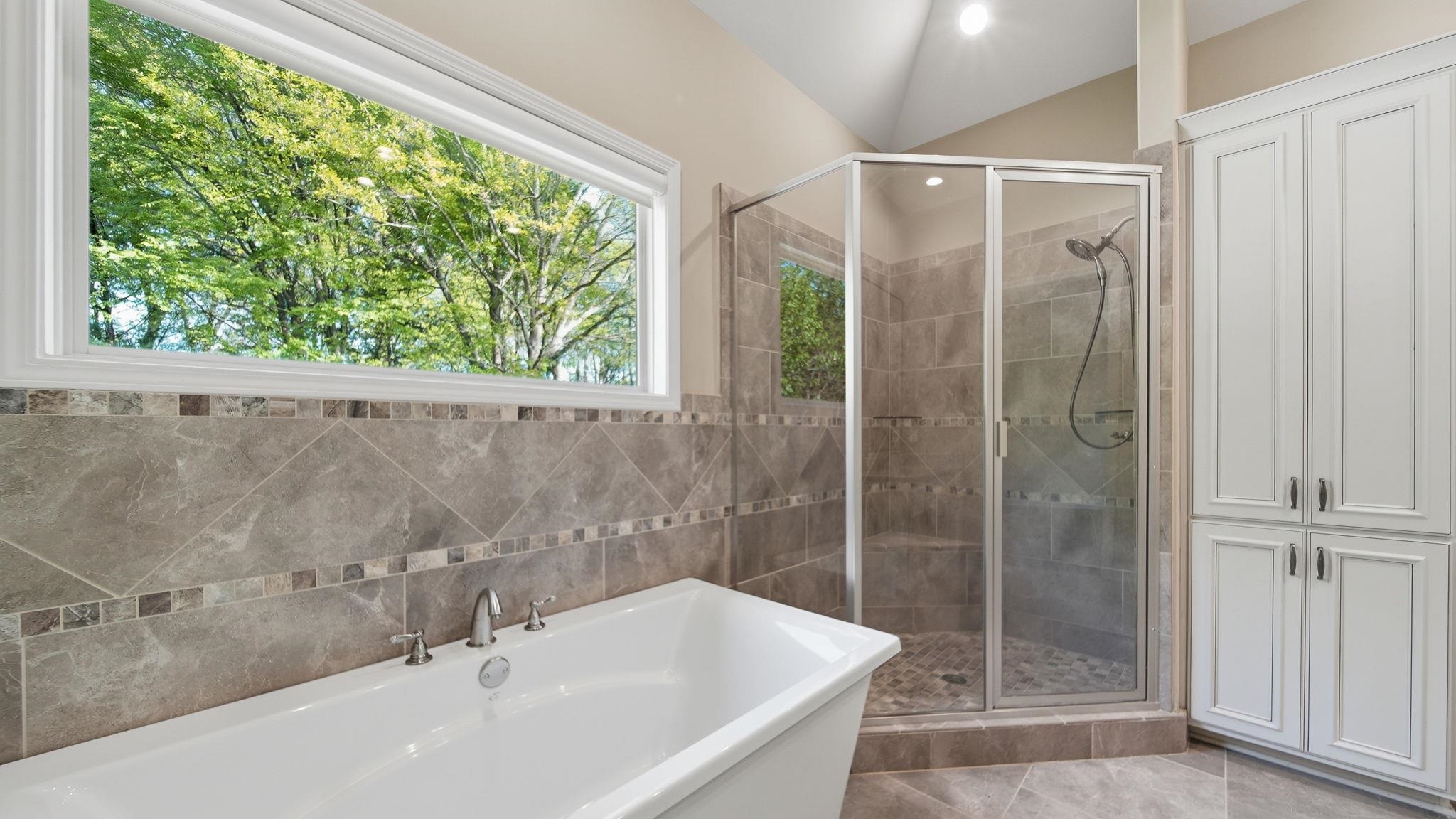 1058 Shanborne Cove Collierville, TN 38017 - Photo 26 of 39 Full bath featuring a freestanding tub, a shower stall, and tile walls