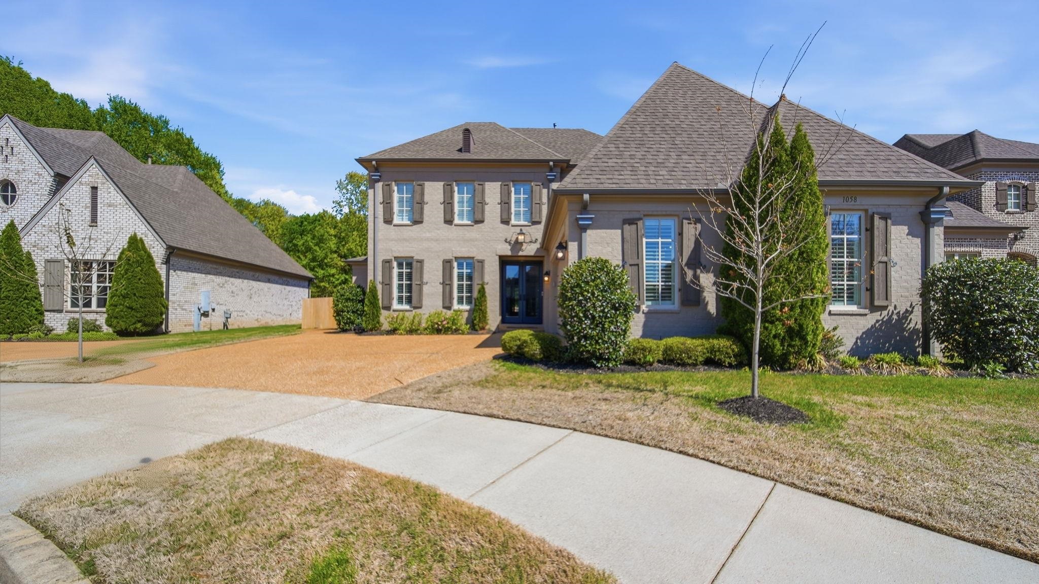 1058 Shanborne Cove Collierville, TN 38017 - Photo 37 of 39 View of front of house featuring a front yard, brick siding, driveway, and a shingled roof