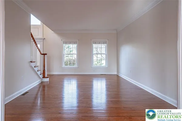 a kitchen with stainless steel appliances granite countertop a refrigerator a sink dishwasher a stove and white countertops with wooden floor