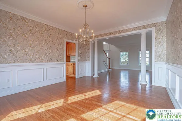 a kitchen with stainless steel appliances granite countertop a refrigerator a sink dishwasher a stove and white countertops with wooden floor