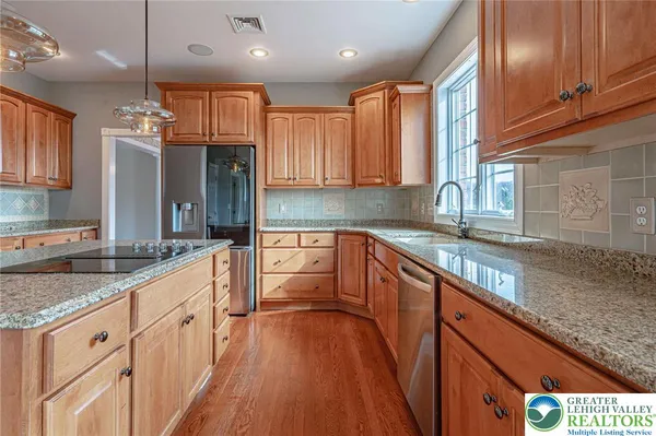 a kitchen with stainless steel appliances granite countertop a refrigerator oven a sink dishwasher and granite countertops with cabinets