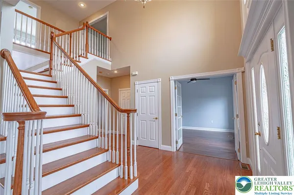 a view of a hallway with wooden floor and stairs