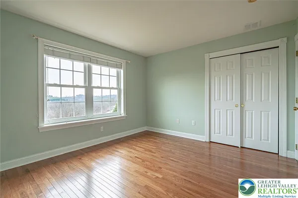 an empty room with windows and entrance to other room