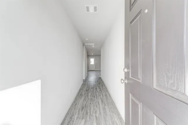 a view of a hallway with wooden floor