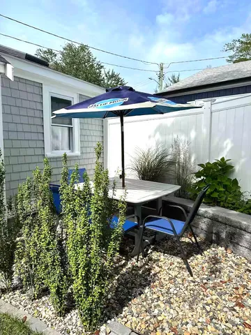 a backyard of a house with table and chairs