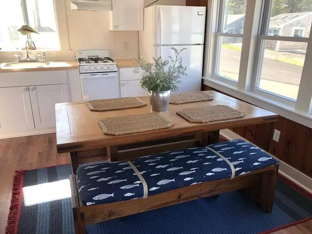 a living room with stainless steel appliances furniture and a potted plant