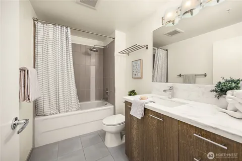 a bathroom with a double vanity sink toilet and shower