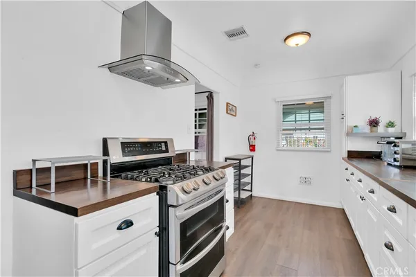 a kitchen with stainless steel appliances a stove microwave and a hard wood floor