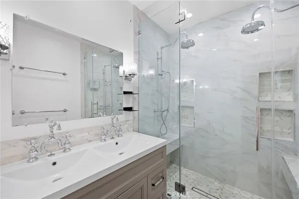 a bathroom with a sink shower and a mirror
