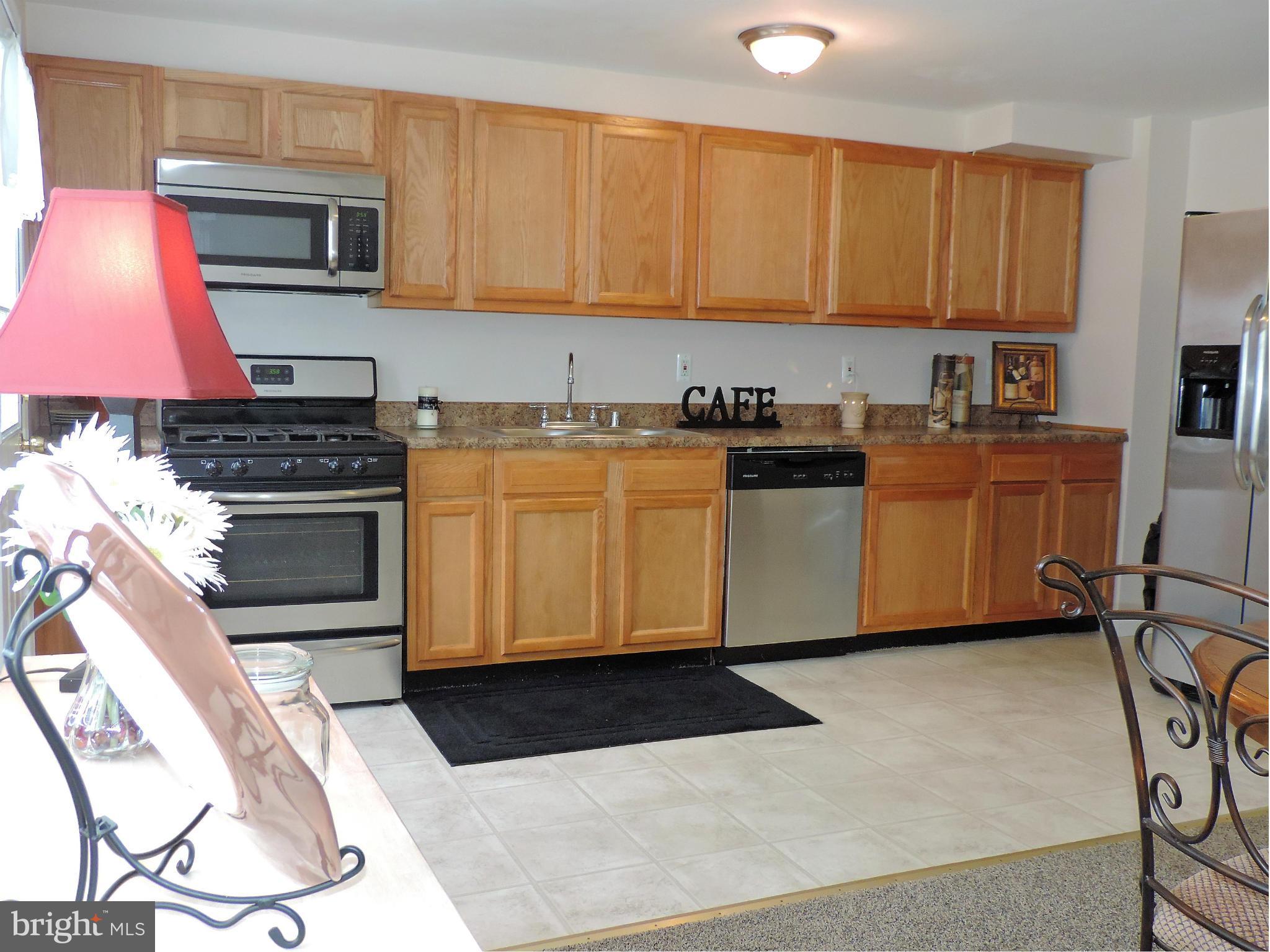 952 Bayner Road Essex, MD 21221 - Photo 8 of 17 a kitchen with stainless steel appliances kitchen island granite countertop a stove a sink and a microwave