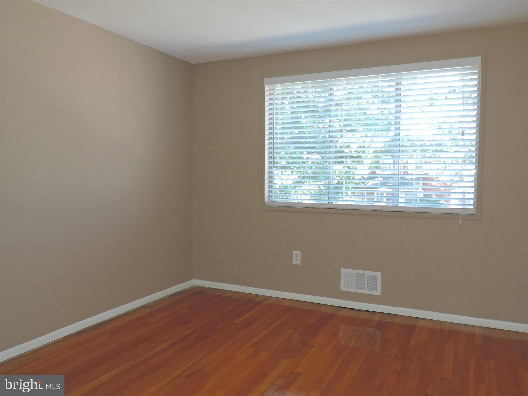 952 Bayner Road Essex, MD 21221 - Photo 9 of 17 a view of an empty room with wooden floor and a window
