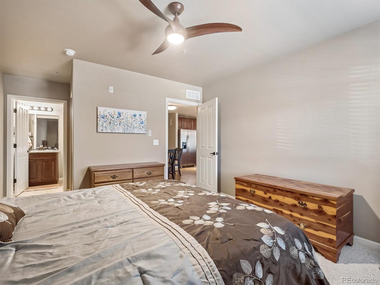 1144 Rockhurst Drive, Unit 107 Highlands Ranch, CO 80129 - Photo 12 of 29 a bedroom with a large bed and a chandelier