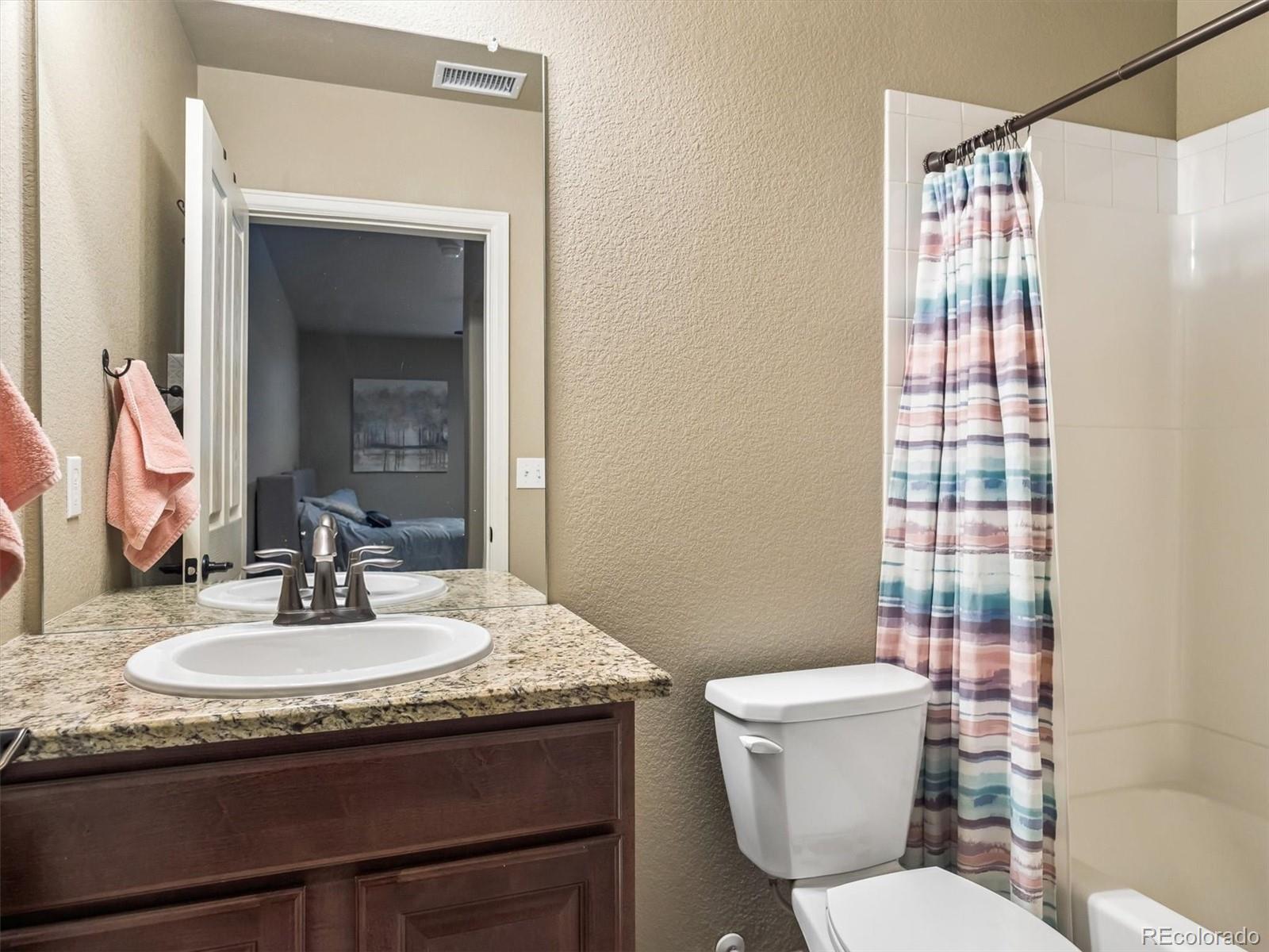 1144 Rockhurst Drive, Unit 107 Highlands Ranch, CO 80129 - Photo 14 of 29 a bathroom with a granite countertop sink toilet and shower