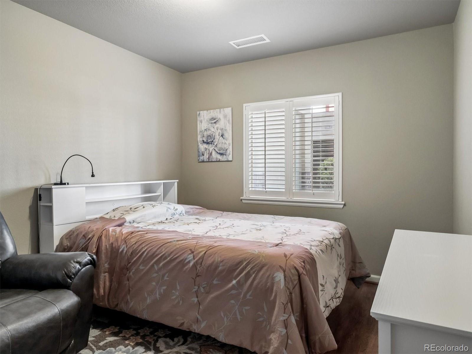 1144 Rockhurst Drive, Unit 107 Highlands Ranch, CO 80129 - Photo 15 of 29 a bedroom with a bed and a window