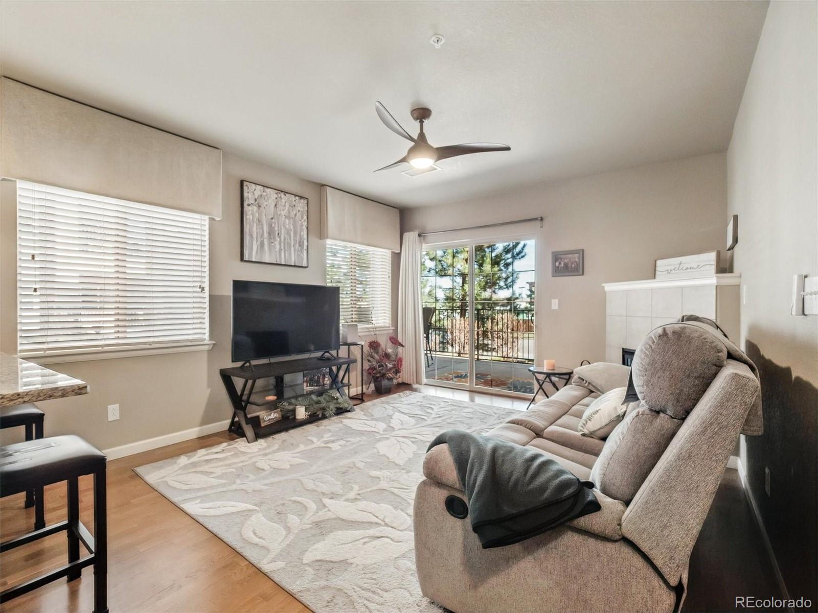 1144 Rockhurst Drive, Unit 107 Highlands Ranch, CO 80129 - Photo 2 of 29 a living room with furniture and a flat screen tv