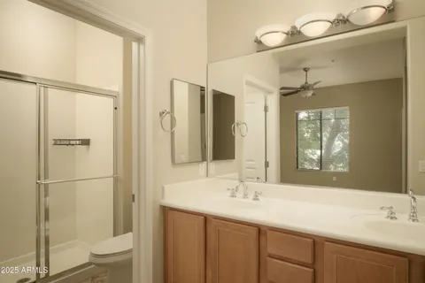 a bathroom with a shower sink vanity mirror and toilet