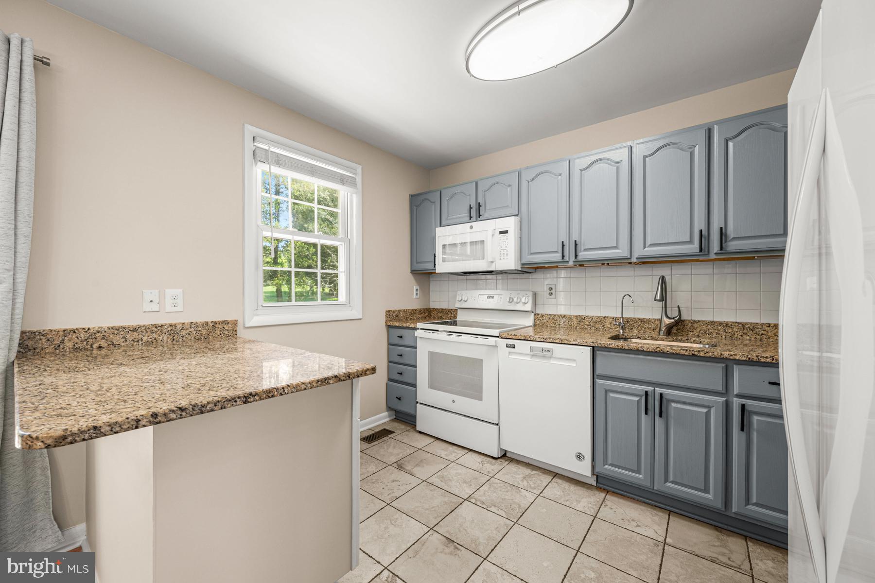 4285 Wolf Hill Drive Hampstead, MD 21074 - Photo 9 of 49 a kitchen with a sink window and cabinets