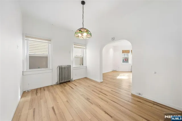 a view of empty room with wooden floor and window