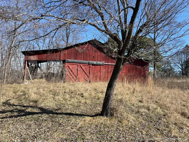 a view of a yard with wooden fence and a bench