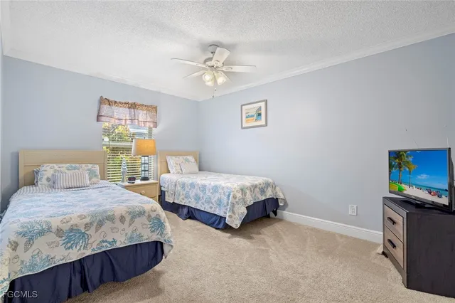 a bedroom with two beds and a flat screen tv