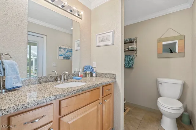 a bathroom with a granite countertop toilet sink and mirror