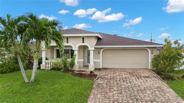 a front view of a house with a yard and trees