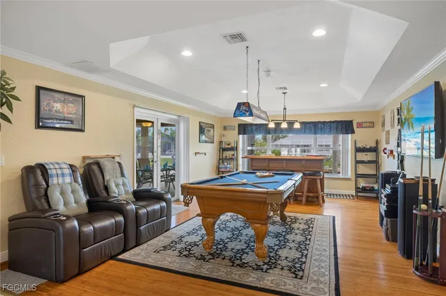 a living room with furniture a wooden floor and kitchen view