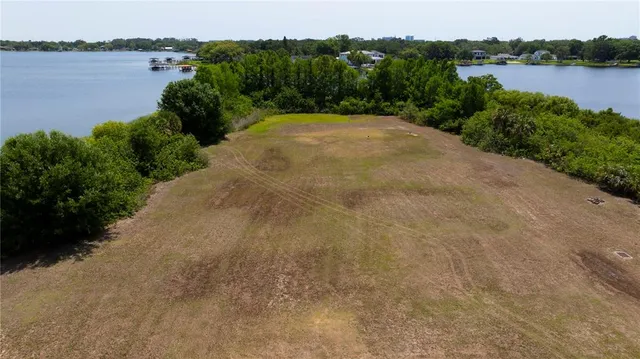 an aerial view of ocean and residential houses with outdoor space
