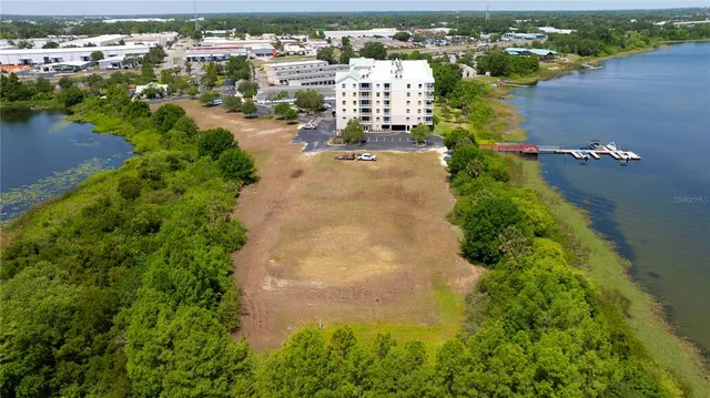 an aerial view of residential houses with outdoor space and lake view