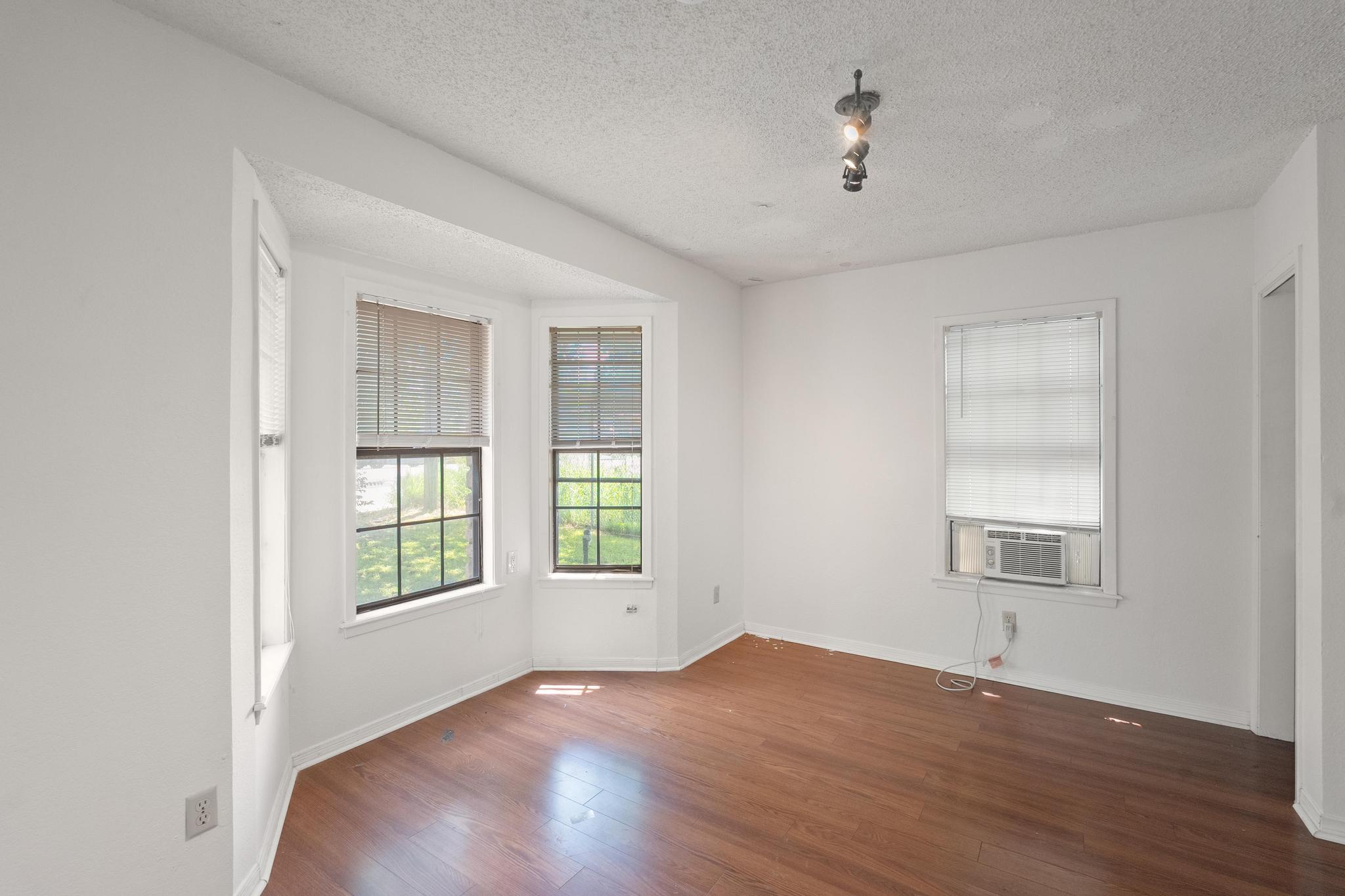 4616 East Cesar Chavez Street Austin, TX 78702 - Photo 4 of 22 an empty room with wooden floor and windows