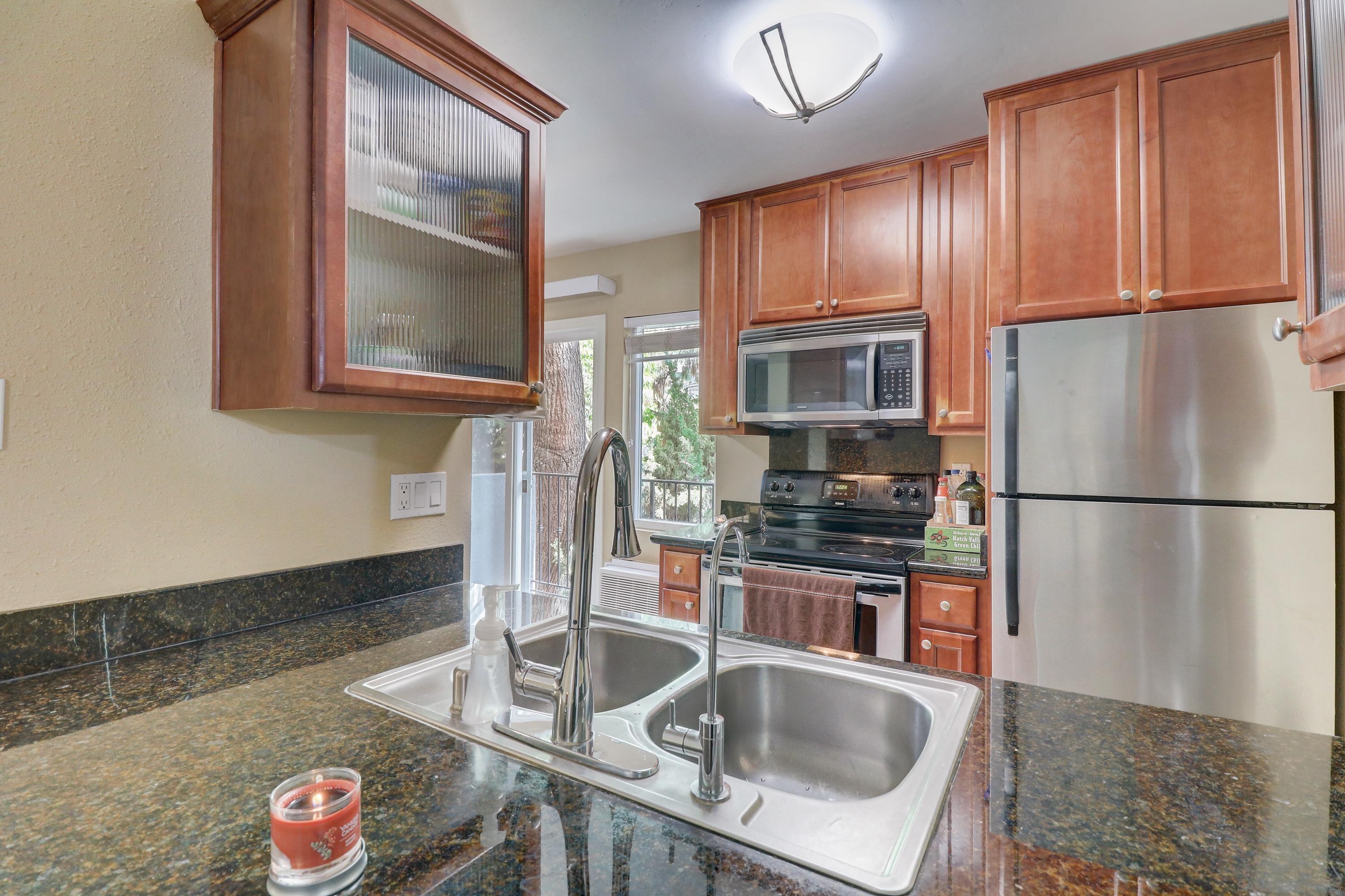 a kitchen with stainless steel appliances granite countertop a refrigerator a stove top oven a sink and dishwasher