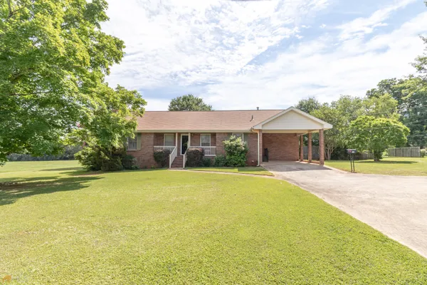 a front view of house with swimming pool and green space