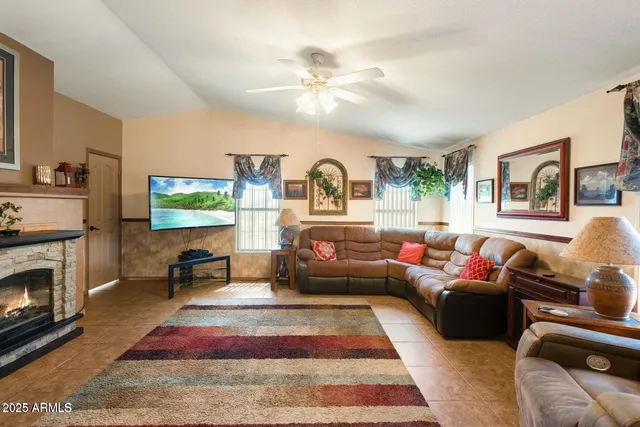 a living room with furniture a flat screen tv and a fireplace