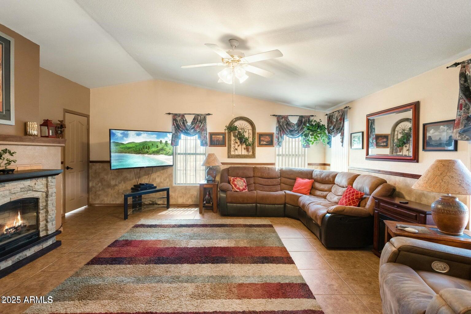 5780 South Mescalero Road Hereford, AZ 85615 - Photo 4 of 45 a living room with furniture a flat screen tv and a fireplace