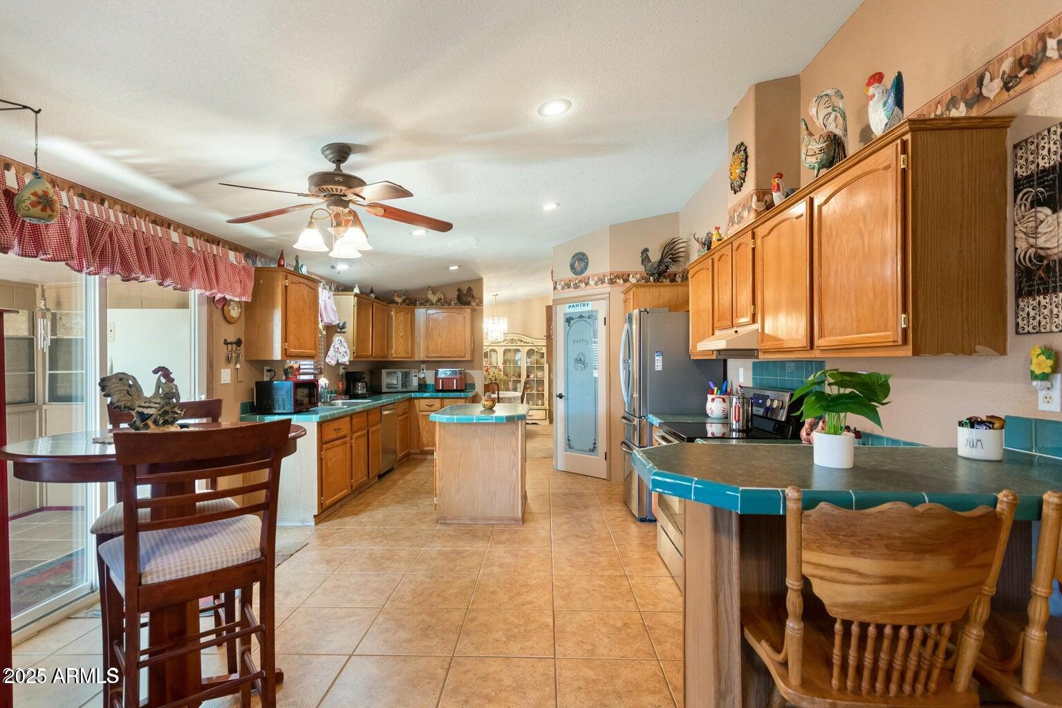 5780 South Mescalero Road Hereford, AZ 85615 - Photo 7 of 45 a kitchen with stainless steel appliances kitchen island granite countertop a stove a sink a dining table and chairs