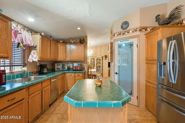 a kitchen with stainless steel appliances granite countertop a refrigerator a sink and a stove