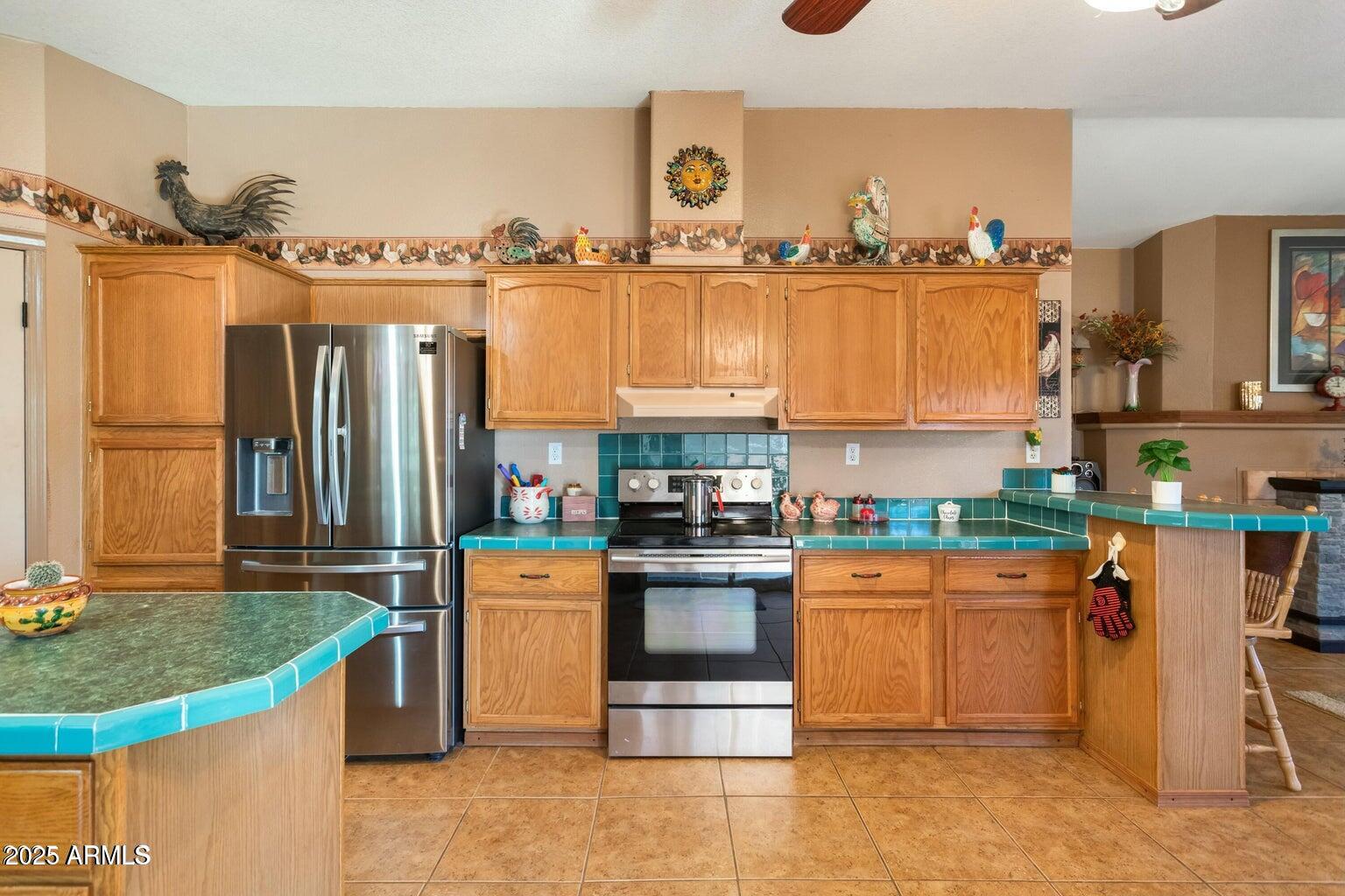 5780 South Mescalero Road Hereford, AZ 85615 - Photo 9 of 45 a kitchen with stainless steel appliances granite countertop a stove and a refrigerator