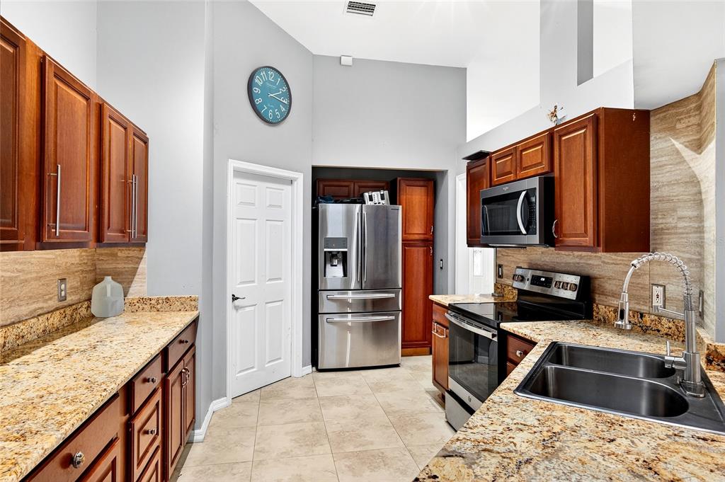 7839 Southwest 63rd Ave Road Ocala, FL 34476 - Photo 19 of 41 a kitchen with stainless steel appliances granite countertop a refrigerator stove and sink