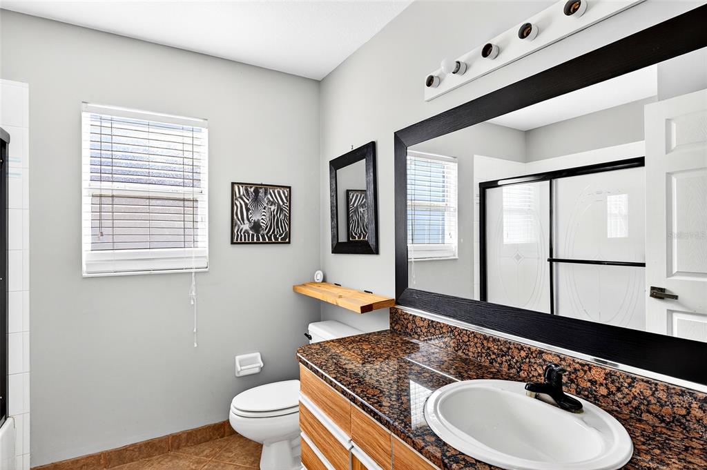 7839 Southwest 63rd Ave Road Ocala, FL 34476 - Photo 28 of 41 a bath room with a toilet a sink and a large mirror