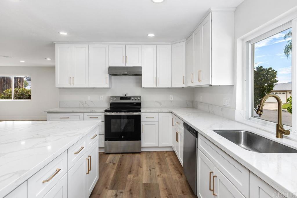 9022 Rupp Court Santee, CA 92071 - Photo 1 of 1 a kitchen with granite countertop white cabinets and white appliances
