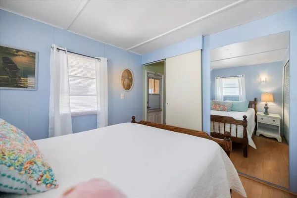 a bedroom with a bed table chair and a window
