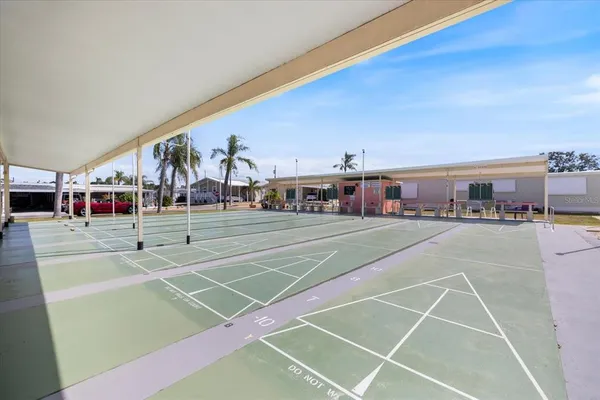a view of a tennis ground with large trees