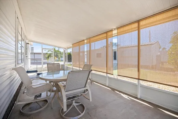 a dining room with furniture and a floor to ceiling window